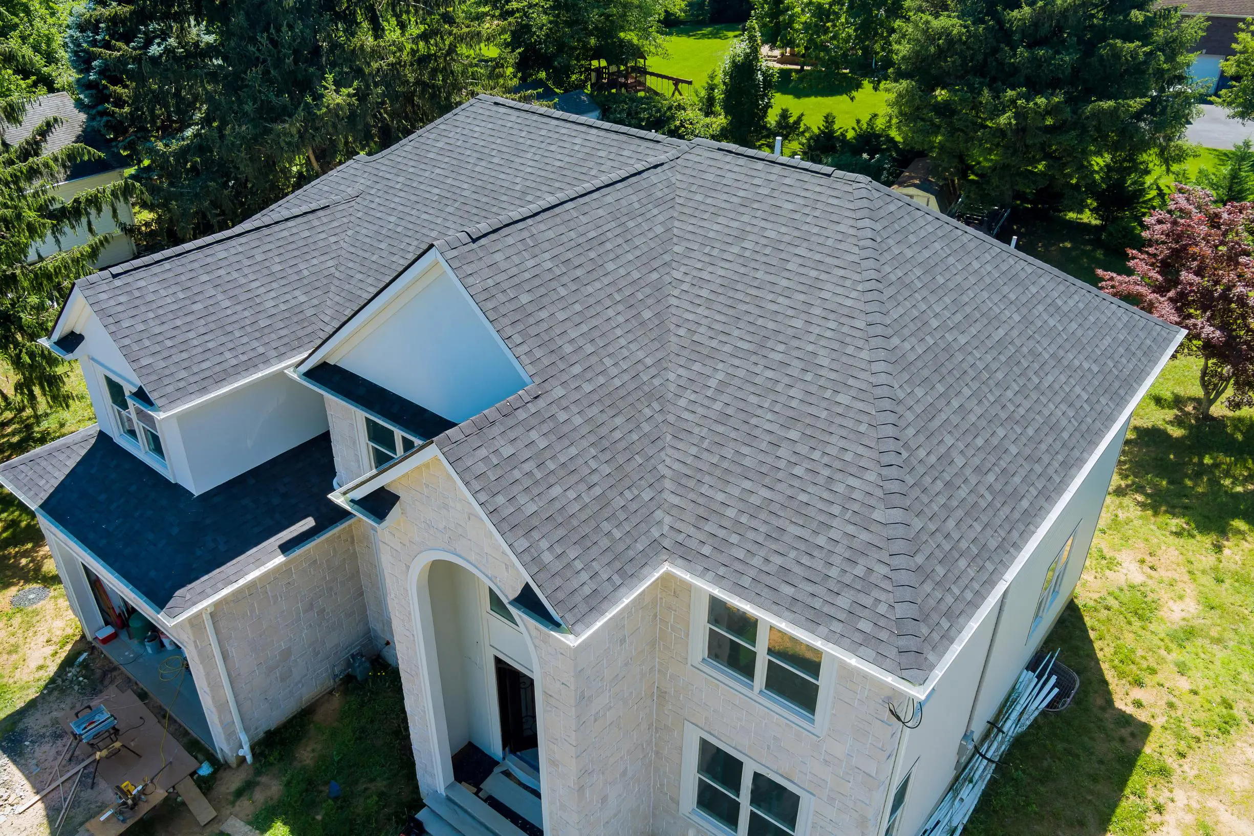 Aerial view of house with gray roof.