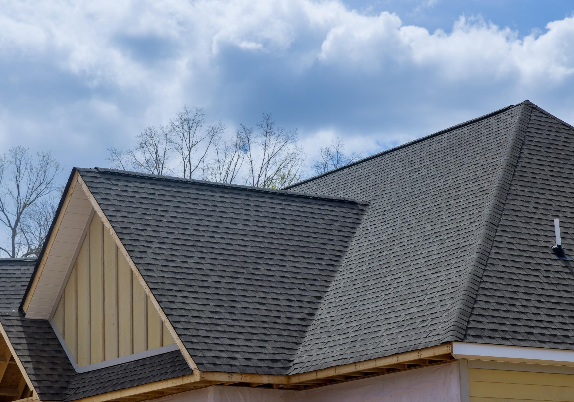 Gray shingle roof under blue sky.