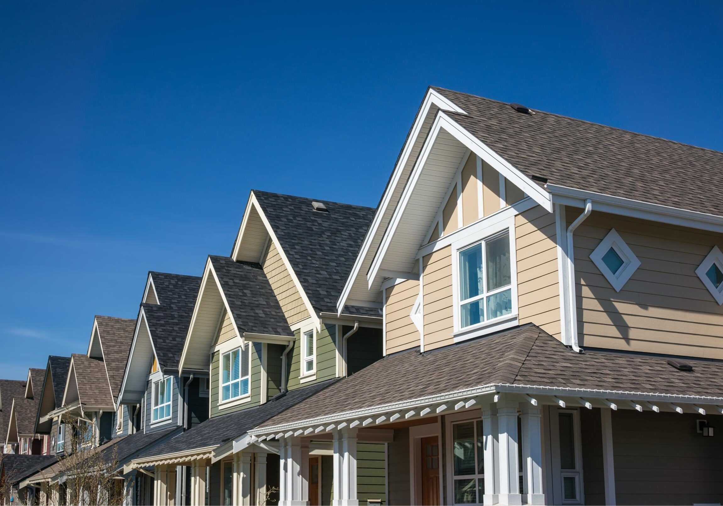 Row of suburban houses under blue sky.